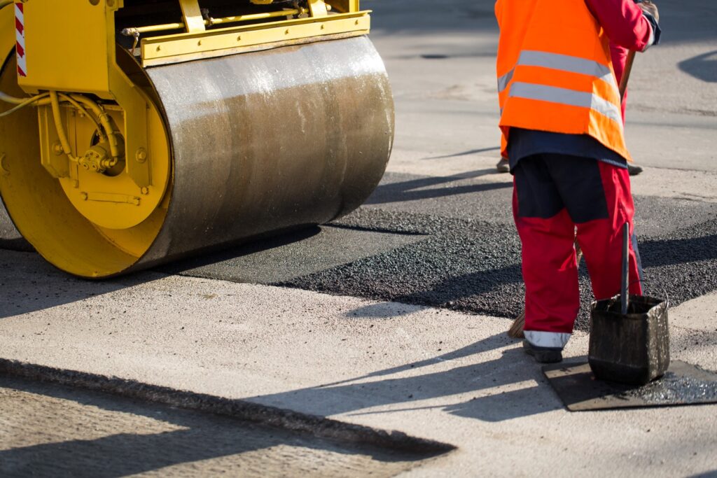 Road repairs. A road roller compacting asphalt.